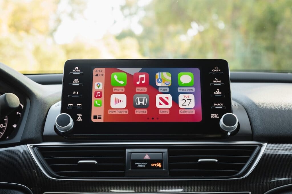 Car dashboard with Apple CarPlay interface display.