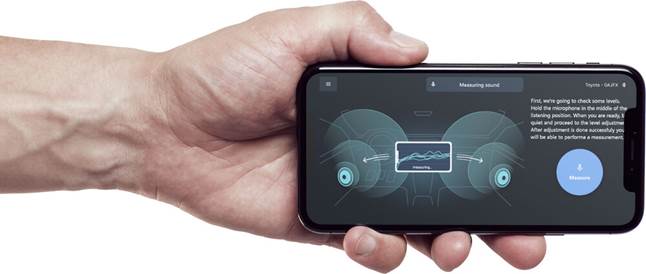 Hand holding phone displaying sound measuring app