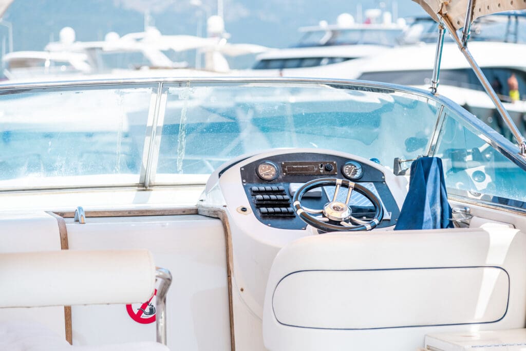Boat cockpit showcasing steering wheel and controls.